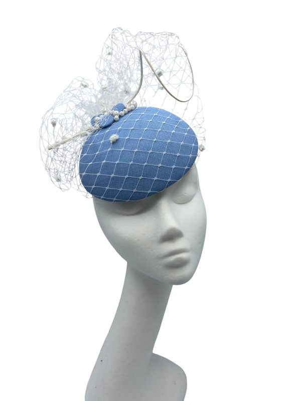 Stunning cornflower blue headpiece with white pom pom veiling overlay.